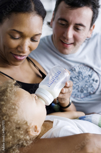 Photo: Man watching his wife feeding their baby son Man watching his wife feeding their baby son