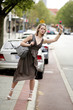A teenage girl trying to stop a cab