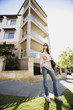 Low angle view of a teenage girl in front of an apartment