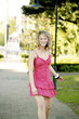 Photo: A teenage girl in pink dress spending time leisurely in a park A teenage girl in pink dress spending time leisurely in a park