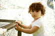 Cute little young girl standing beside a cage