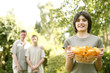 Photo: Teenage girl holding a bowl of chips with her father and brother standing in the background Teenage girl holding a bowl of chips with her father and brother standing in the background