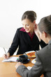 Businesswomen eating while having discussion