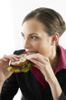 Businesswoman eating sandwich