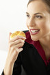 Businesswoman eating bun