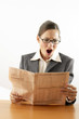 Businesswoman opening her mouth wide while reading newspaper