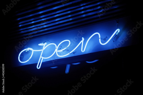 Photo: Blue neon open sign illuminating under the dark Blue neon open sign illuminating under the dark
