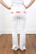 Woman with the word 'fragile' on her white jeans