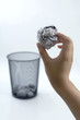 Foto: Hand throwing crumpled paper into dustbin Hand throwing crumpled paper into dustbin