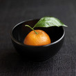 Close up of clementine in a black bowl