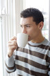 Man drinking coffee while enjoying the view from the window