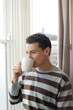 Man drinking coffee while enjoying the view from the window