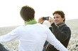 Two men taking pictures on the beach