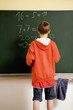 Boy solving an equation on the blackboard