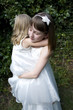 Sisters wearing white dress embracing