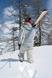 Rear view of a man holding snowboard walking away from camera