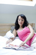 Woman reading magazine on the bed