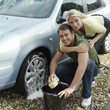 Photo: Man washing car wheel, woman hugging him from behind Man washing car wheel, woman hugging him from behind