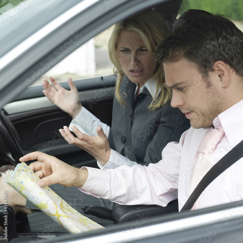 Photo: Businessman referring to map, businesswoman complaining Businessman referring to map, businesswoman complaining