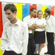 Boy and girls whispering, boy looking sad