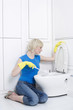 Woman with rubber gloves cleaning the toilet bowl