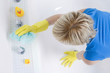 Woman with rubber gloves, cleaning the bathtub
