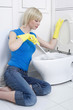 Woman with rubber gloves cleaning the toilet bowl