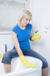 Woman with rubber gloves, cleaning the bathtub