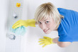 Woman with rubber gloves, cleaning the bathtub
