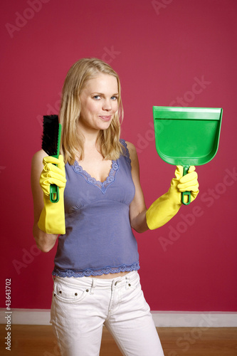 Photo: Woman with rubber gloves holding a hand broom and dust pan Woman with rubber gloves holding a hand broom and dust pan