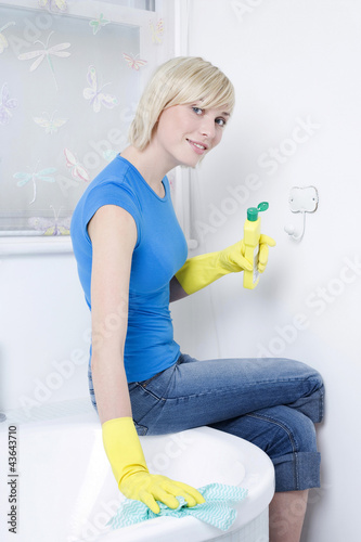 Photo: Woman with rubber gloves, cleaning the bathtub Woman with rubber gloves, cleaning the bathtub