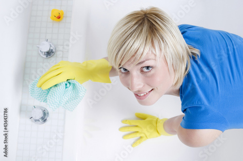 Photo: Woman with rubber gloves, cleaning the bathtub Woman with rubber gloves, cleaning the bathtub