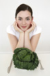 Woman resting her chin on palms, cabbage on plate
