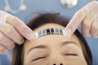 Male doctor pressing a disposable thermometer on patient's forehead