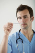 Male doctor looking at thermometer