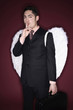 Businessman with angel wings putting his finger on lips