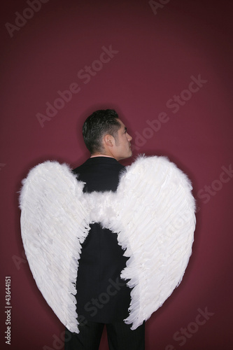 Photo: Businessman with angel wings looking away Businessman with angel wings looking away