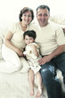 A young boy sitting between his father and mother on the couch