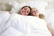 A woman and her daughter lying on the bed together