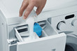 Man pours detergent into the washing machine