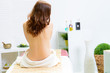 junge frau sitzt entspannt auf de massageliege
