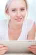 Foto: closeup portrait of smiling young happy woman using a tablet PC closeup portrait of smiling young happy woman using a tablet PC