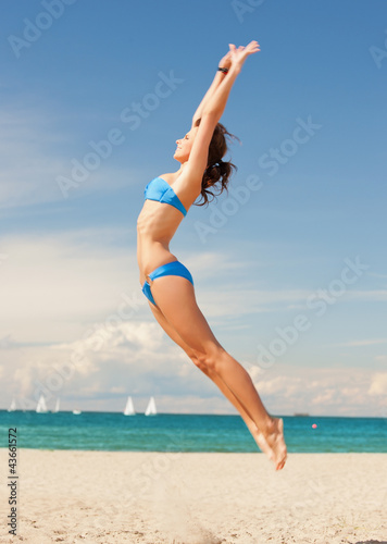 Photo: happy jumping woman on the beach happy jumping woman on the beach