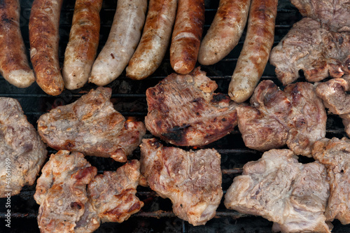 Photo: Assorted meat cooking on a barbeque Assorted meat cooking on a barbeque