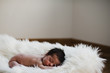 Little newborn sleeping and dreaming on a carpet