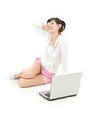 yung woman sitting on the floor with laptop, full length
