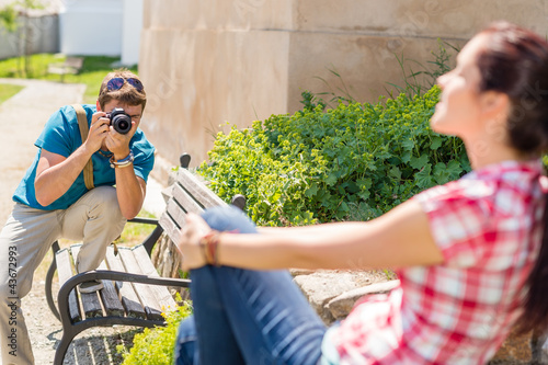 Photo: Man taking pictures of woman on bench Man taking pictures of woman on bench