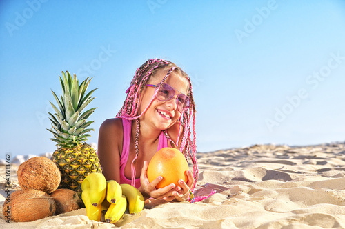 Photo: Happy child with fruit on the beach Happy child with fruit on the beach