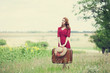 Redhead girl with suitcase at outdoor.