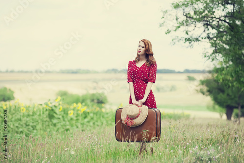 Photo: Redhead girl with suitcase at outdoor. Redhead girl with suitcase at outdoor.